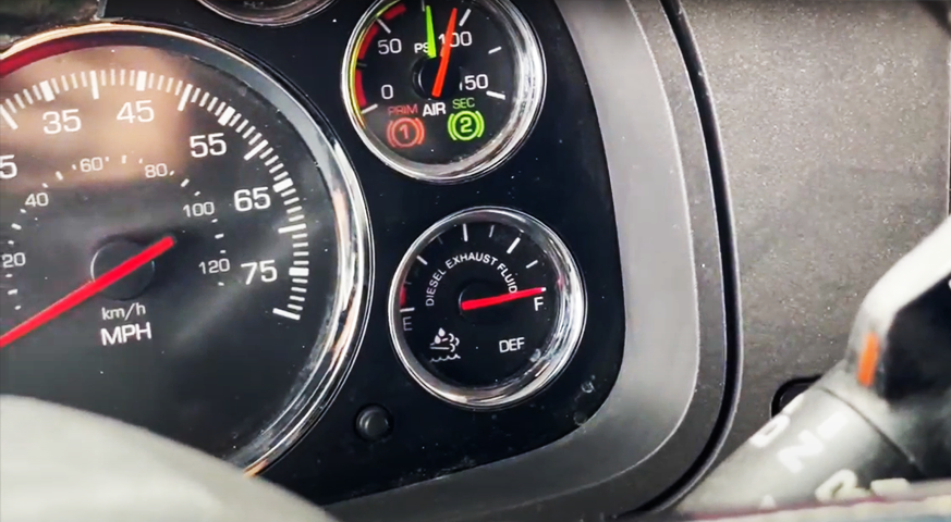 Truck dashboard showing DEF fluid gauge, highlighting Diesel Exhaust Fluid levels for maintenance insights.