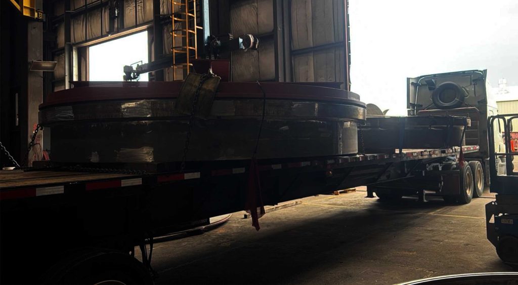 Oversize flange assembly loaded on a flatbed trailer inside an industrial warehouse.