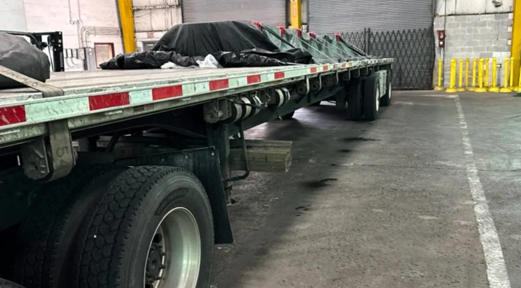 Tarped flatbed trailer carrying six skids from Chicago, Illinois to East Troy, Wisconsin.